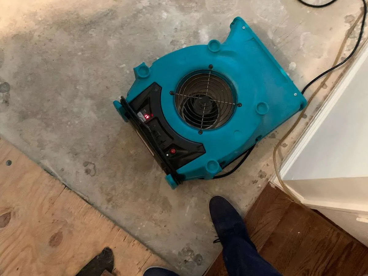 Air mover drying subfloor during Commercial Water Damage Restoration in Bellefontaine